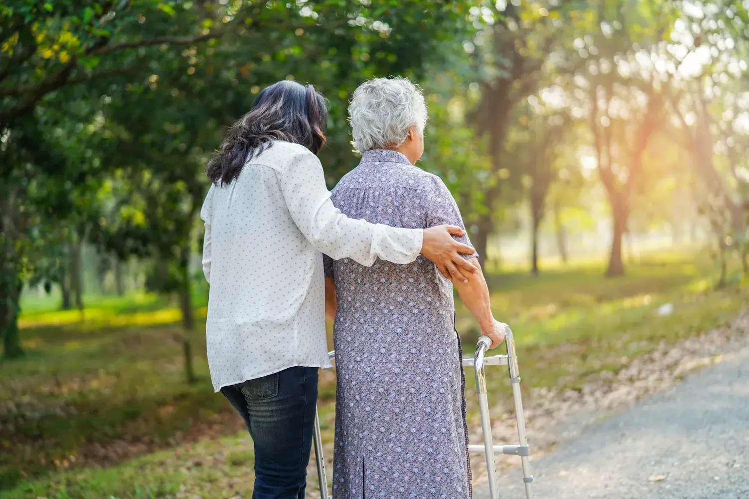 Hilfe und Pflege: Eine asiatische Seniorin oder ältere Dame nutzt einen Rollator und ist bei bester Gesundheit im Park unterwegs. Sie ist fröhlich und fröhlich.